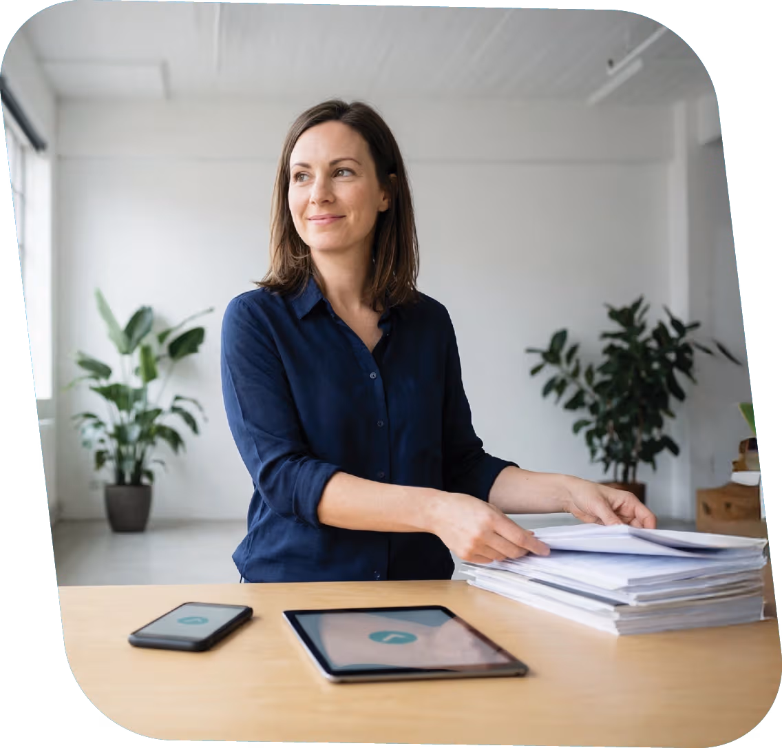 Woman sitting at a desk with smartphone and tablet